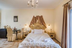 a bedroom with a bed and a table and a chandelier at Pothitis sun studios in Megás Limniónas +26 photos