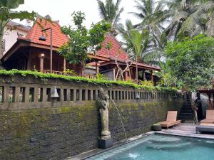 a house with a water fountain in front of a building at Sweet Orange Pondok in Ubud