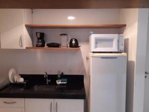 een kleine keuken met een spoelbak en een magnetron bij Hotel Via Park- NF e Wi-Fi in Campos dos Goytacazes