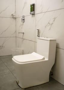 um WC branco numa casa de banho com paredes em mármore em The Vintage Haven Munnar em Devikolam