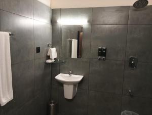 um banheiro com uma pia e um espelho em The Vintage Haven Munnar em Devikolam