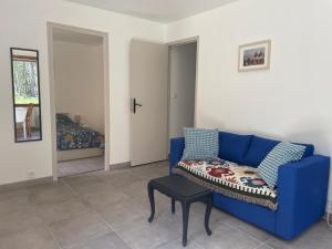 a living room with a blue couch and a table at L'Olympe in Brantes
