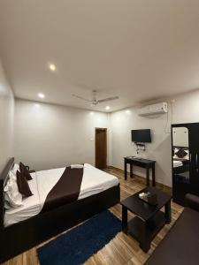 a bedroom with a bed and a tv and a table at Bloom Villa in Guwahati