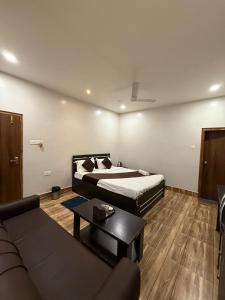 a hotel room with a bed and a couch at Bloom Villa in Guwahati