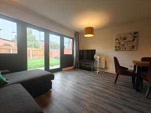 een woonkamer met een bank, een tafel en een televisie bij Park Central 4 Double Bedroom House in Birmingham City Center in Birmingham