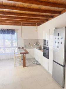 eine Küche mit weißen Geräten und einer Holzdecke in der Unterkunft Marina in La Santa