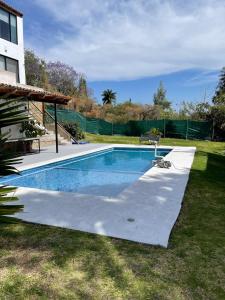 a swimming pool in a yard next to a house at Departamento en Chapala in Ixtlahuacán de los Membrillos