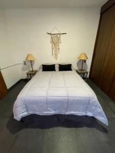 a bedroom with a large bed with two lamps at Departamento en Chapala in Ixtlahuacán de los Membrillos