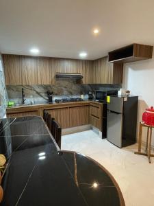 a kitchen with a black counter top and a black refrigerator at Departamento en Chapala in Ixtlahuacán de los Membrillos