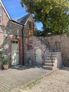 a brick house with two doors and a staircase at The Stable in Usk