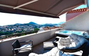 a balcony with a hot tub and chairs on a roof at Dubrovnik Icy Guest House in Dubrovnik