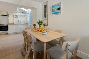 een keuken en eetkamer met een houten tafel en stoelen bij Picnic Cottage - Family Retreat near Dartmouth in Kingswear