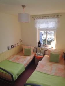 two beds in a room with a window at Ferienhaus Rumpelt in Kurort Gohrisch