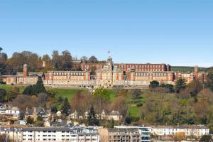 een groot gebouw bovenop een heuvel met gebouwen bij Picnic Cottage - Family Retreat near Dartmouth in Kingswear