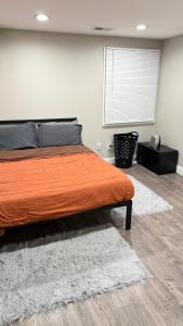 a bedroom with an orange bed and a window at Rooms available in a single Family home shared with Host in Willingboro