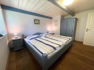 a bedroom with a large bed with a blue wall at Pörksen Huus in Aventoft