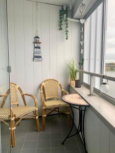 a balcony with two chairs and a table at Panoramablick Ostseefjord Schlei in Schleswig