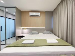 a bedroom with a bed with two towels on it at Modernidade e Luxo no 30º Andar in Campo Grande +12 photos