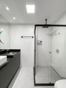 a bathroom with a glass shower and a sink at Modernidade e Luxo no 30º Andar in Campo Grande