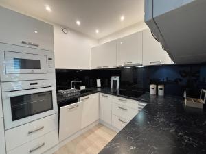 a kitchen with white appliances and black counter tops at Apartmán Zelené Atrium Premium in Trnava
