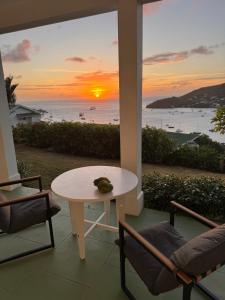 una mesa y sillas en una habitación con vistas al océano en Admiralty View Ground Floor - Bequia, en Belmont