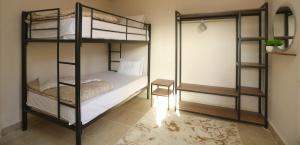 1 Schlafzimmer mit 2 Etagenbetten und einem Stuhl in der Unterkunft Darya's Studios - Stylish &Comfy Apartments, New Cairo in Kairo