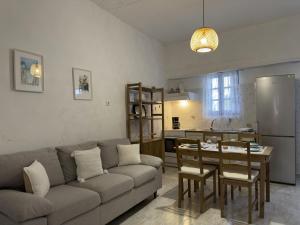 a living room with a couch and a table and a kitchen at yiayia's Place in Chora Folegandros