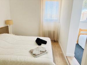a white bed with a black bag on top of it at Villa T4, île de la marina, parking in Cap d'Agde