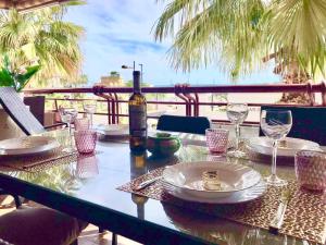 a table with a bottle of wine and glasses at Mar y Vistas Puerto Santa Pola in Santa Pola