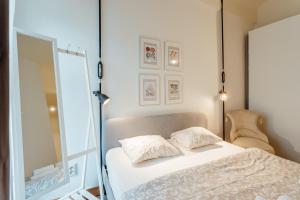 a bedroom with a white bed and a mirror at Apartmán CityPulse in Banská Štiavnica