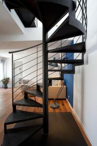 - un escalier en colimaçon noir dans une chambre avec un canapé dans l'établissement Appartement L'Armande, à Arles