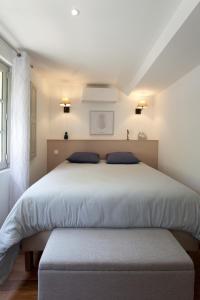 une chambre avec un grand lit avec des oreillers bleus dans l'établissement Appartement L'Armande, à Arles