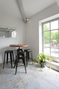 - une table et des tabourets dans une chambre avec fenêtre dans l'établissement Appartement L'Armande, à Arles