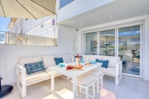 a white dining room with a table and chairs at Fishermans Lodge in La Cala de Mijas