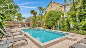 una piscina con sedie e una casa di Barbuda Suite by Last Key Realty a Key West