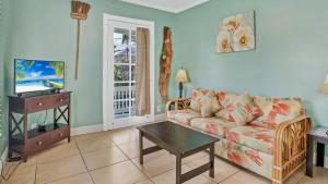 un soggiorno con un divano e una TV di Barbuda Suite by Last Key Realty a Key West