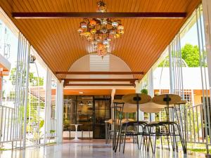 a dining room with tables and chairs and a chandelier at Nine Rise Travellers Inn in Plaridel +7 photos