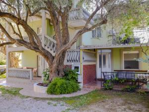 a yellow house with a tree in front of it at Apartments Oliva in Utjeha
