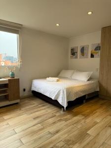 a bedroom with a bed and a wooden floor at Beautiful Apto in Poblado in Medellín