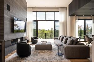 a living room with a couch and a fireplace at NEW! Chalet Aurora 5 Bedrooms Hot tub Outdoor Pool in La Conception