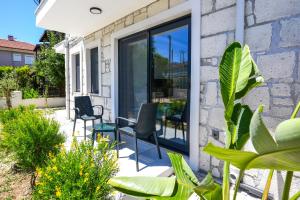 a patio with chairs and plants on a house at Meva Luxury Apartments in Muğla