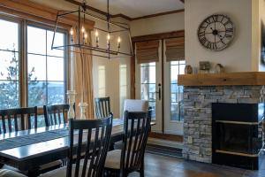 une salle à manger avec une table et une cheminée dans l'établissement Equinox Condo On-Resort Luxury Direct Ski Access Stunning View, à Mont-Tremblant
