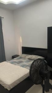 a bedroom with a bed with a fan on the floor at Raheem luxury 3 bedroom in Jabang