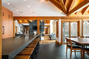 eine offene Küche und ein Esszimmer mit einer großen Arbeitsplatte in der Unterkunft Grand Foret Villa Luxurious Chalet with Hot Tub and Outdoor Firepit in Mont-Tremblant