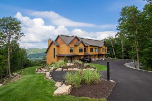 a large yellow house with a driveway at Havre Des Legendes 102 Luxurious, Contemporary Easy Walk to Ski-in/Out in Mont-Tremblant
