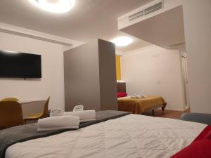 a bedroom with a large bed with a tv on the wall at CconfortHotels Suite 104 in Bari