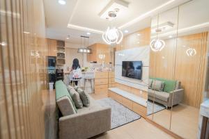 ein Wohnzimmer mit Couch und Küche in der Unterkunft Kamilla's Stay - 2 Bed Rooms Apartment in Kejayan