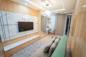 ein Wohnzimmer mit Couch und Flachbildfernseher in der Unterkunft Kamilla's Stay - 2 Bed Rooms Apartment in Kejayan