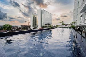 ein Schwimmbad auf dem Dach eines Gebäudes in der Unterkunft Kamilla's Stay - 2 Bed Rooms Apartment in Kejayan