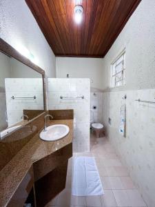 a bathroom with a sink and a toilet and a mirror at Solar Lages - Diamantina - MG in Diamantina